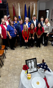 Group of adults with flags and a memorial table
