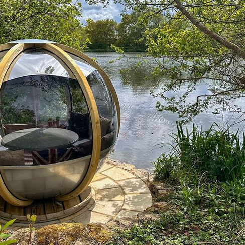 A round outdoor pod by a lake