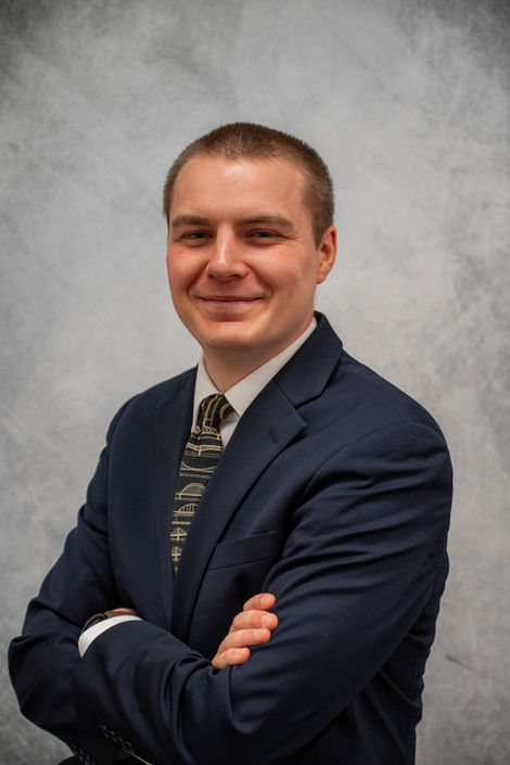 Corporate headshot of a businessman with arms crossed in a navy suit, taken in Washington County, PA.