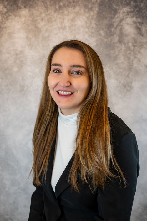 Professional headshot of a woman in a black blazer against a soft mottled backdrop in Washington, PA.