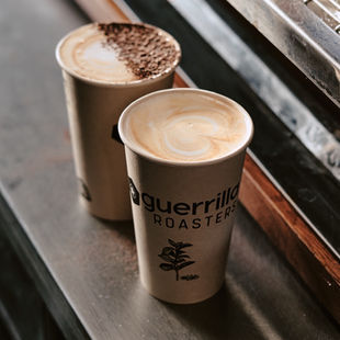 two coffees in i am not paper cups with guerrilla roasters branding, lids off, ready for cafesmart day