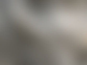 Stone sculpture of a serene face kissing an infant, with intricate carved details and closed eyes. Gray texture and calm mood.