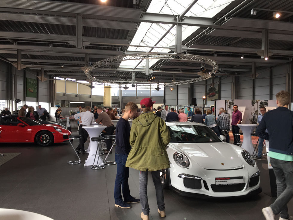 Begeisterte Zuschauer bei einer Veranstaltung im Porsche Zentrum Paderborn, die von spannenden Präsentationen und unterhaltsa