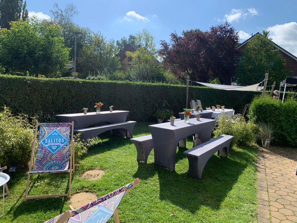 Entspannte Atmosphäre auf der Gartenparty mit eleganten Lounge-Möbeln und dekorativen Details.