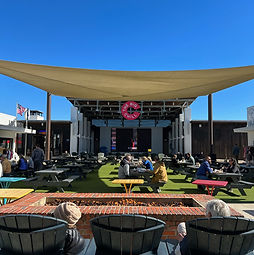People relaxing at The Big Chill 30A in Watersound Beach Florida with lawn seating, food options, and large event screen