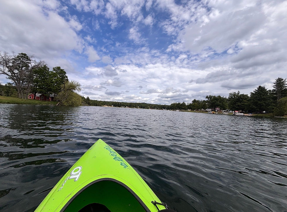Paddling through the serene waters of West Michigan, Chelsea takes in the picturesque lakeside views from her bright green kayak.