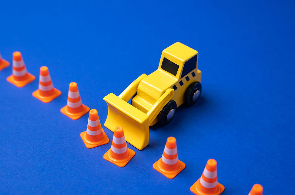 Yellow bulldozer moving traffic cones