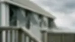 Exterior Bahama shutters propped open on a coastal beach house facade in soft overcast daylight