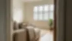 Affordable plantation shutters on a bright living room window casting soft shadow stripes across pale wood floors