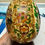 Thumbnail: Hand holding intricately decorated egg on a wooden stand