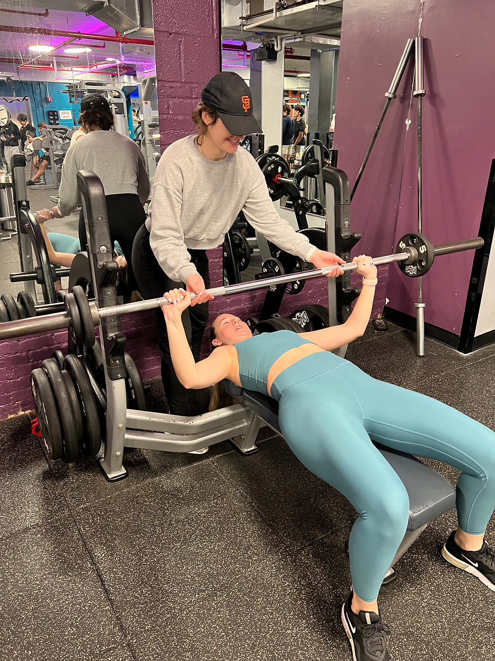 person helping another lift weights