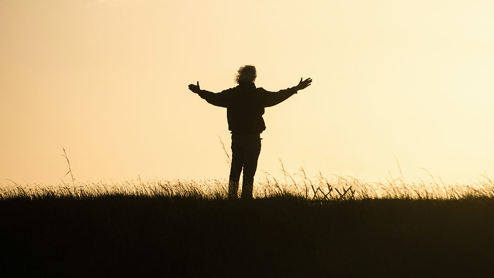 Silhouette of a person holding out arms in gratitude