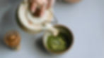 A hand pouring green tea