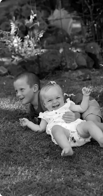 Children playing and laughing outdoors, capturing a joyful and candid family moment