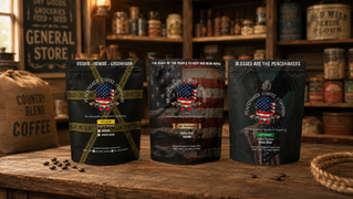Three Peacemaker Coffee Company light, medium, and dark roast coffee bags on a rustic wooden table in a small-town country store..