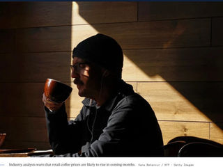 Drinking coffee in a dark hat and glasses sipping coffee