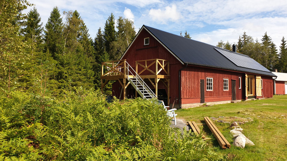 Trappa som leder upp till övervåningen till en röd lada på landet.