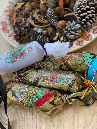 Eco conscious Christmas crackers covered with red and green bio glitters