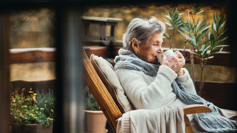 Dementia caregiver taking a quiet moment of rest with a cup of tea, representing the importance of self-care.
