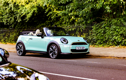 MINI Cooper Convertible in Ocean Wave Green - roof down in a neutral city location.