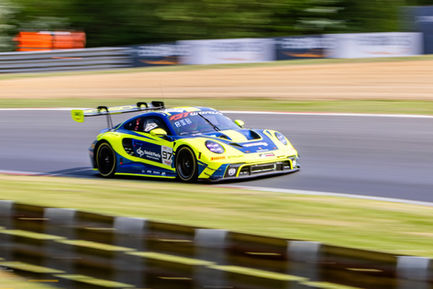 Panning shot of a Porsche 911 GT3 R (992) competing at Brands Hatch Race Circuit.