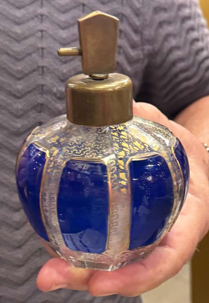 Mexican fashion designer Armando Mafud holding a perfume bottle in his shop (personal archive)