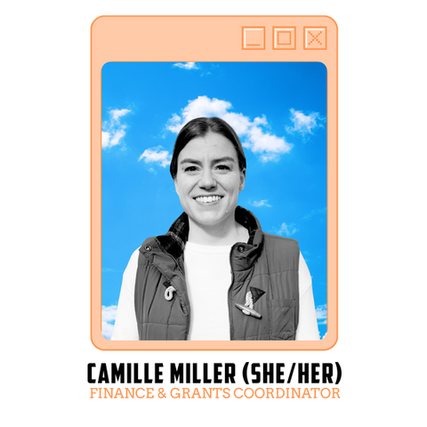 A black and white photo of Camille, the Finance and Grants Coordinator. She is a white woman with her dark blond hair in a low pony tail. She is smiling and wearing a white shirt with a dark vest over it.