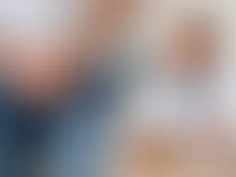 Hombre con jeans y manos en el abdomen. Médico con bata blanca y estetoscopio observa modelo de órgano en una oficina neutral.