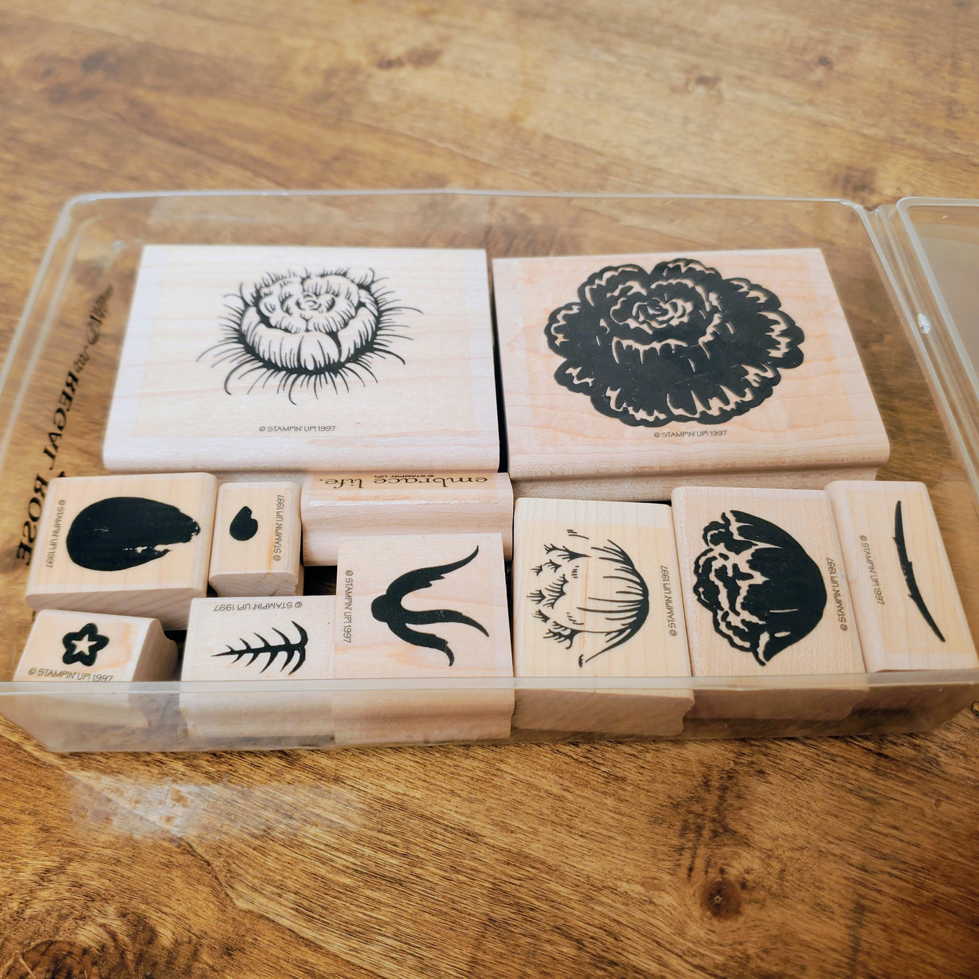 A complete set of vintage wood-mounted rubber stamps featuring elegant floral designs and rose buds.