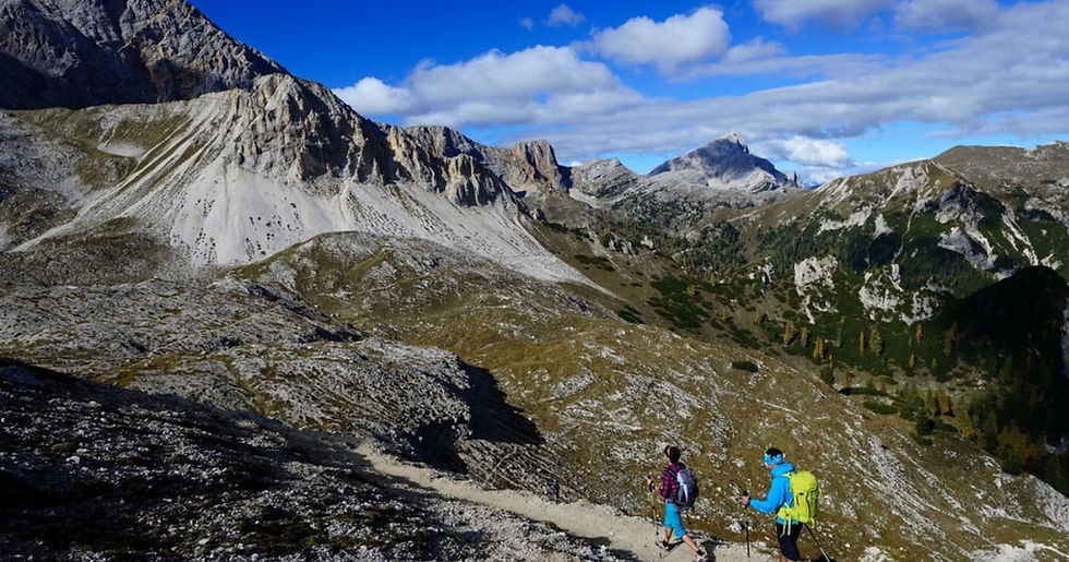 Wandelaars onderweg in de natuur tijdens groepswandelreis, ontspannen tempo en genieten van landschap tijdens wandelvakantie