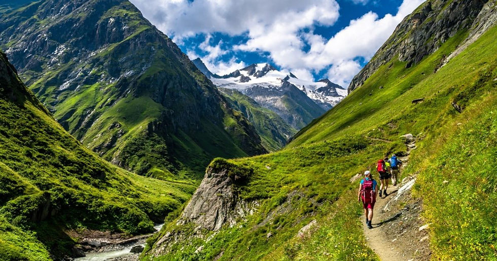 Groepswandelreis door berglandschap met kleine groep wandelaars op natuurpad tijdens actieve wandelvakantie