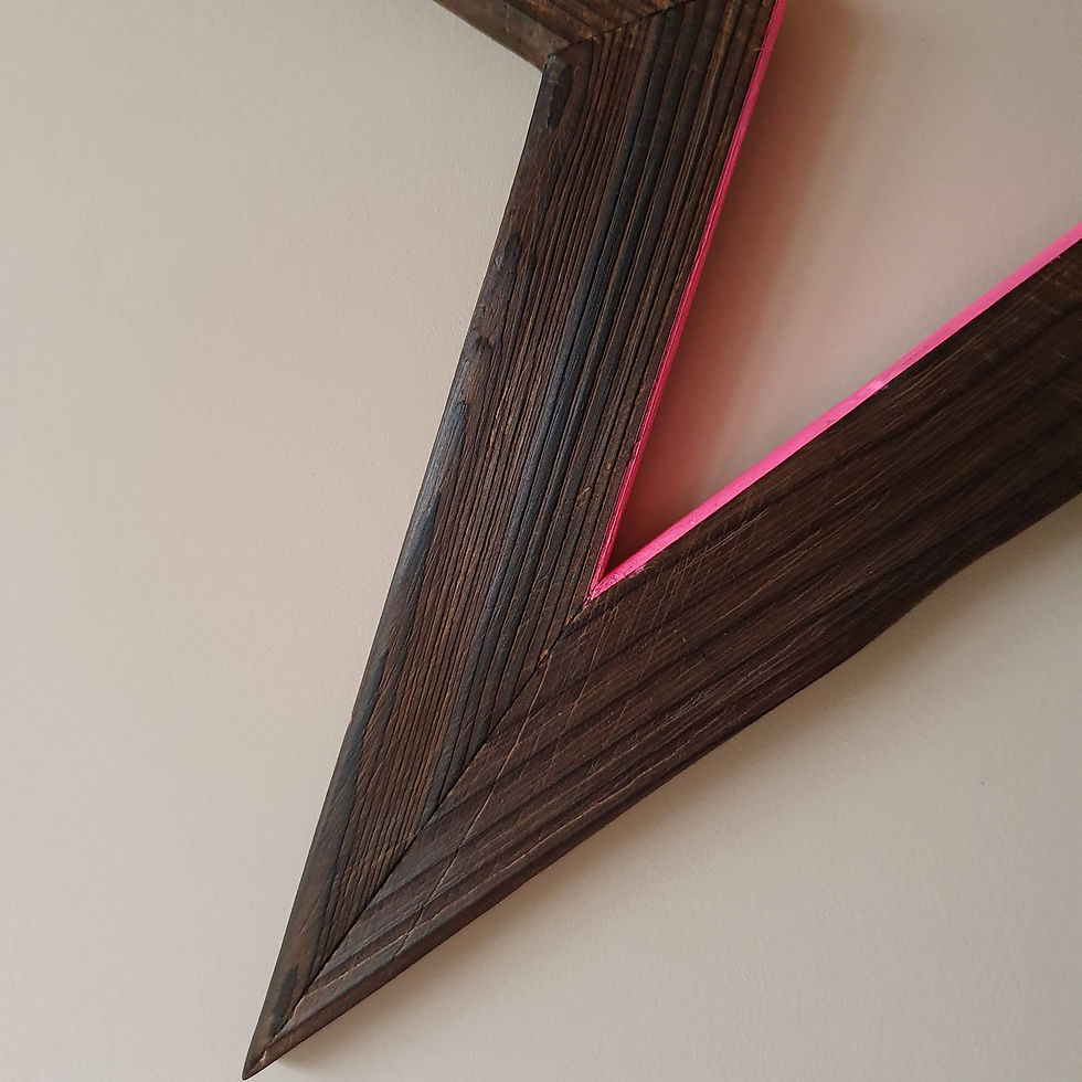 Thumbnail: Charred wooden star painted with neon pink on pink wall point close up