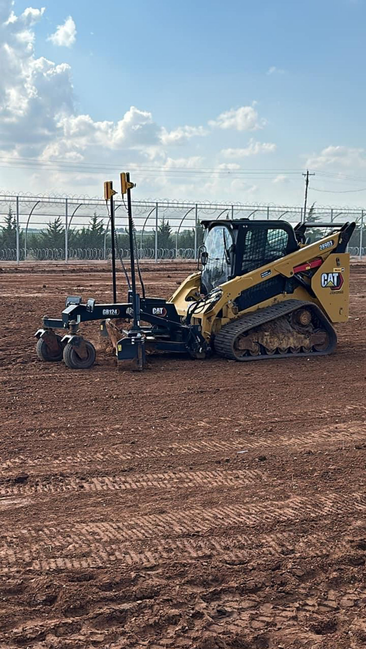 skid loader with blade attachment grading a lot