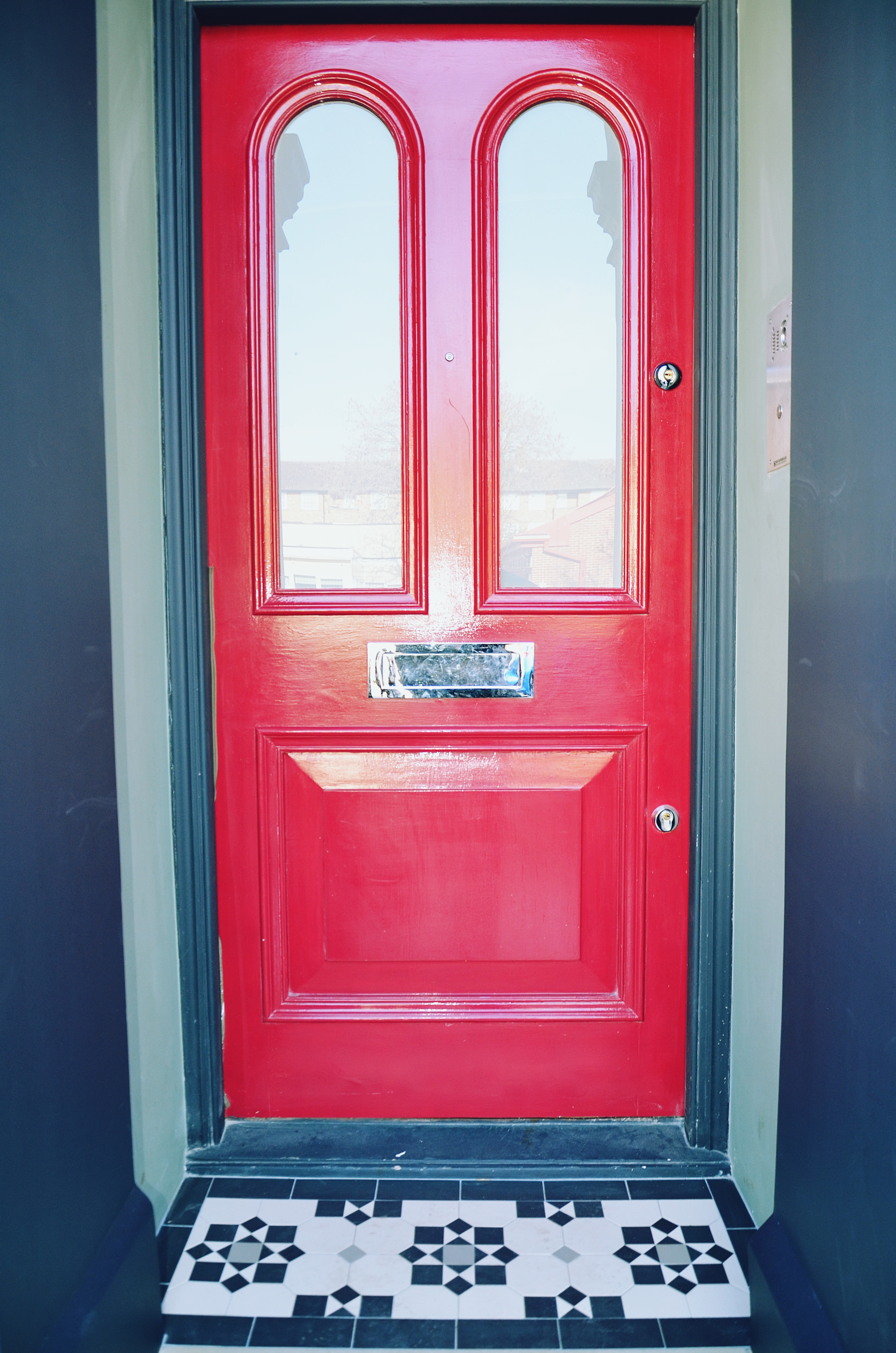 Victorian restoration with modern twist red door with porch mosaic