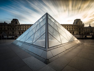 fotografia da piramide do museu Louvre durante um por do sol em longa exposição