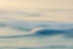 Fotografia de pequena onda sobre a superfície calma do oceano.