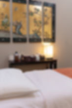 Acupuncture treatment room displaying treatment table and oriental art on the wall