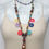 Thumbnail: Flat wood multi color beads, tan leather tassel