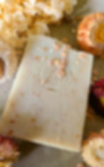 natural oat and honey soap bar with botanical flowers and textured surface showing handmade detail