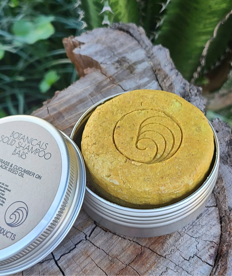 Thumbnail: Yellow Lemongrass solid shampoo bar with logo in round tin on tree stump, natural eco-friendly hair care product in
