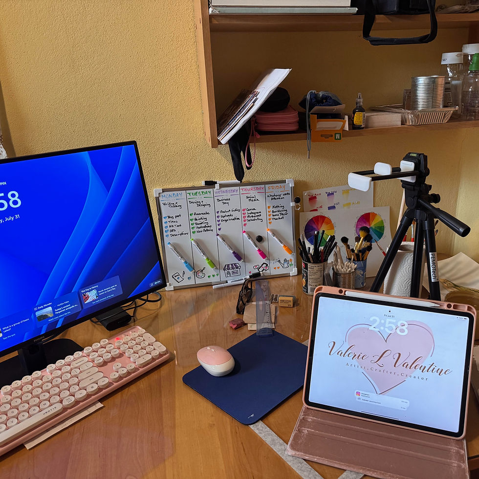 Neat home desk with pink keyboard, monitor, tablet, art supplies, tripod, and weekly planner on shelves; creative, organized feel.