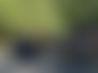 Line of vehicles entering Glacier National Park beside entrance sign.