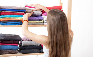 Donna che organizza i vestiti