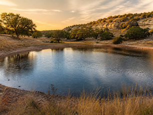 Hill Country ranch pond and limestone hills illustrating Texas water rights for landowners.