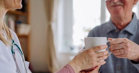 close-up-of-doctor-holding-cup-of-tea-and-talking