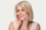 A woman looking happy noticing her skin improvement.