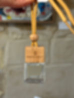 Tiny glass bottle with wooden lid against a blurred stone background