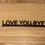 Thumbnail: The words Love you, Bye in black on a brown grained wood background
