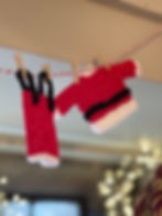 Tiny knitted Santa outfit hanging on a washing line