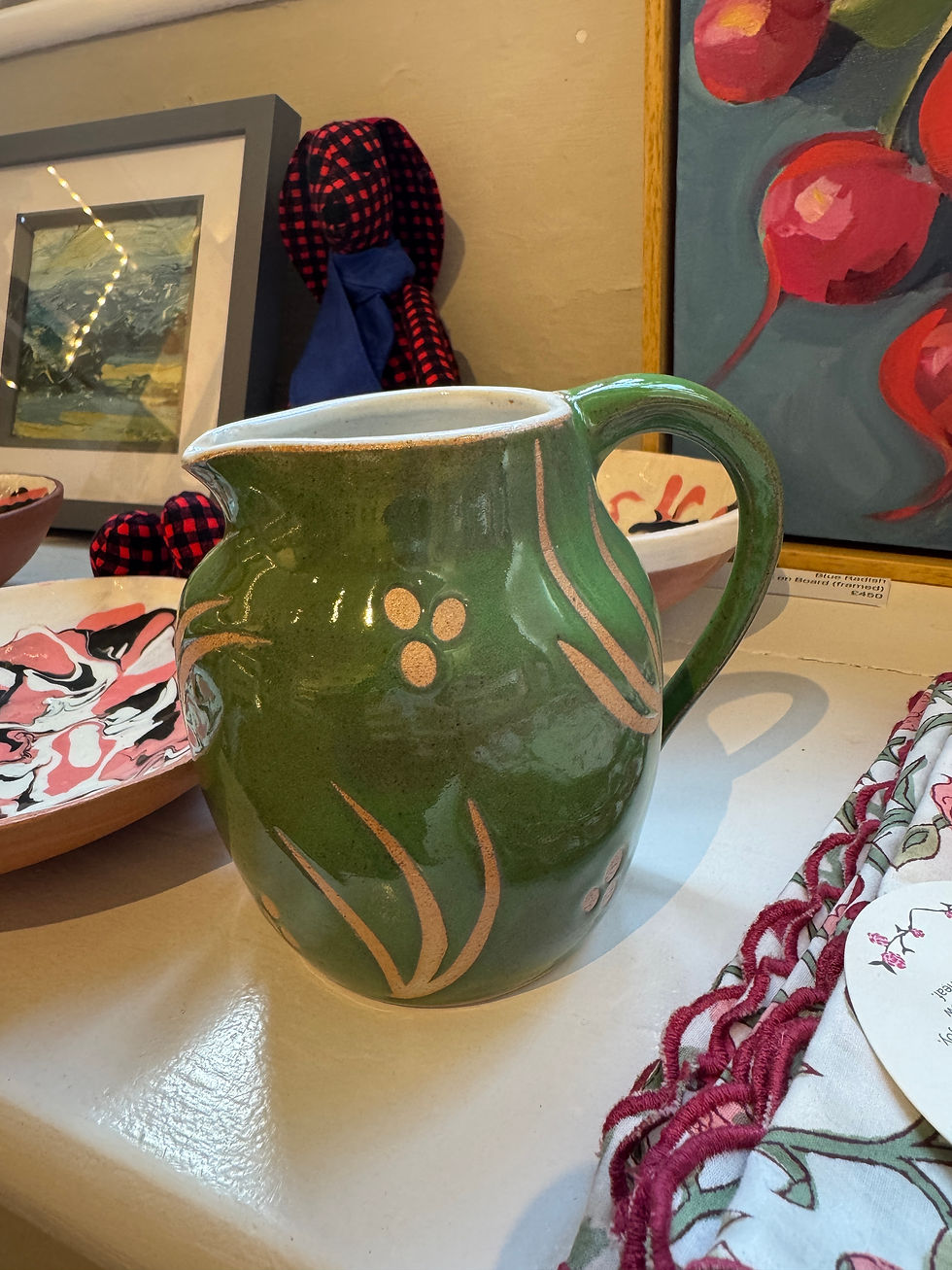Thumbnail: Vibrant Green jug with white interior sitting on a white shelf surrounded by other home items